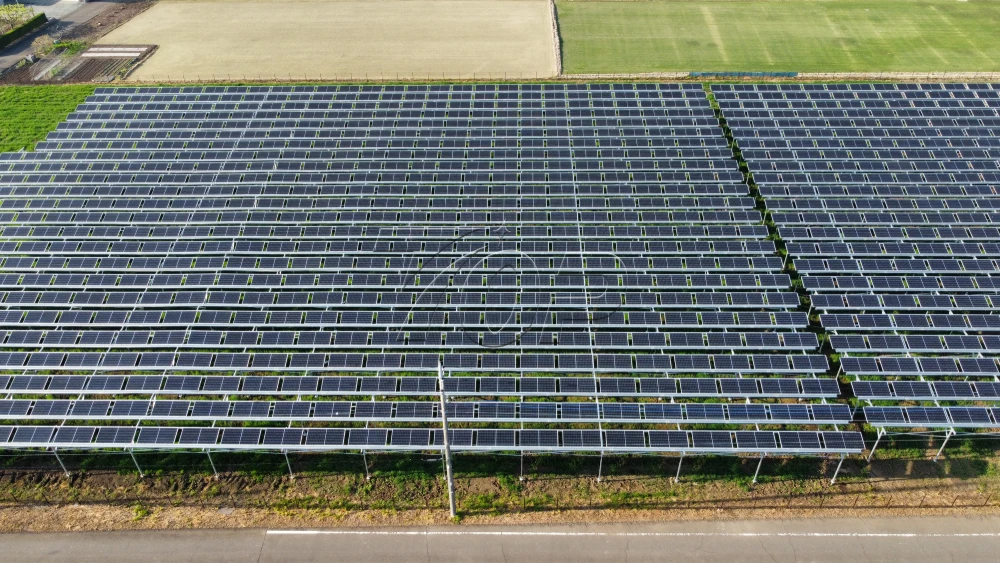 茨城県つくば市の営農型太陽光発電所(第134発電所)の全景俯瞰写真。広大な敷地に設置されたZAM材架台とソーラーパネル。