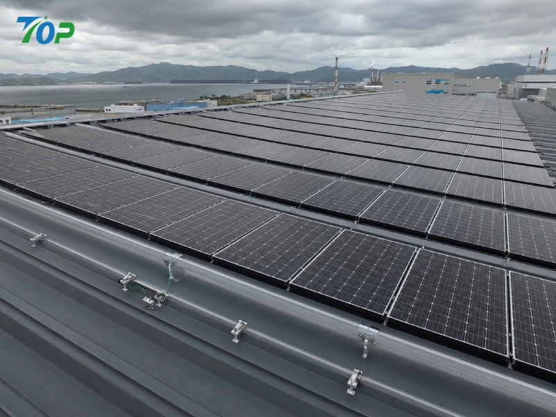 日本の沿岸工業地帯における波板屋根用の縦型太陽光発電架台システムは、非貫通型クランプとAL6005-T5レールを採用した耐台風設計となっている。