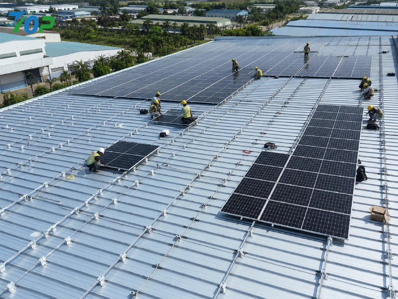 折板屋根にクランプ固定された産業用屋根太陽光システムの施工中の様子